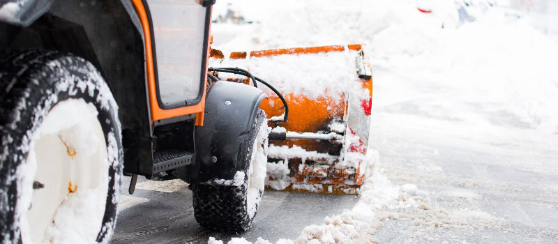 Schneepflug räumt die Straßen in der Stadt, Winterdienst